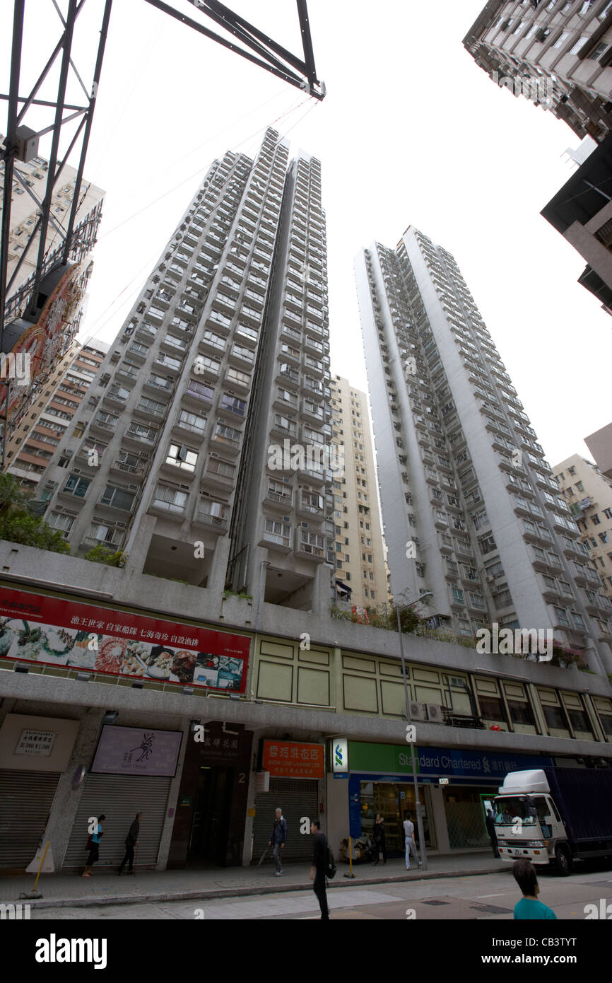 Cerca de gran altura de apartamentos de vivienda sobre tiendas Queens Road al oeste de la isla de Hong Kong Región Administrativa Especial de Hong Kong de China Foto de stock