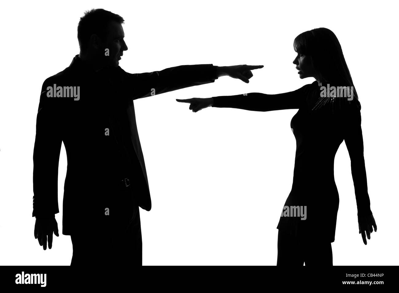 Un hombre y una mujer caucásica pareja uno frente a otro, expresando su acusación en studio silueta aislado sobre fondo blanco. Foto de stock