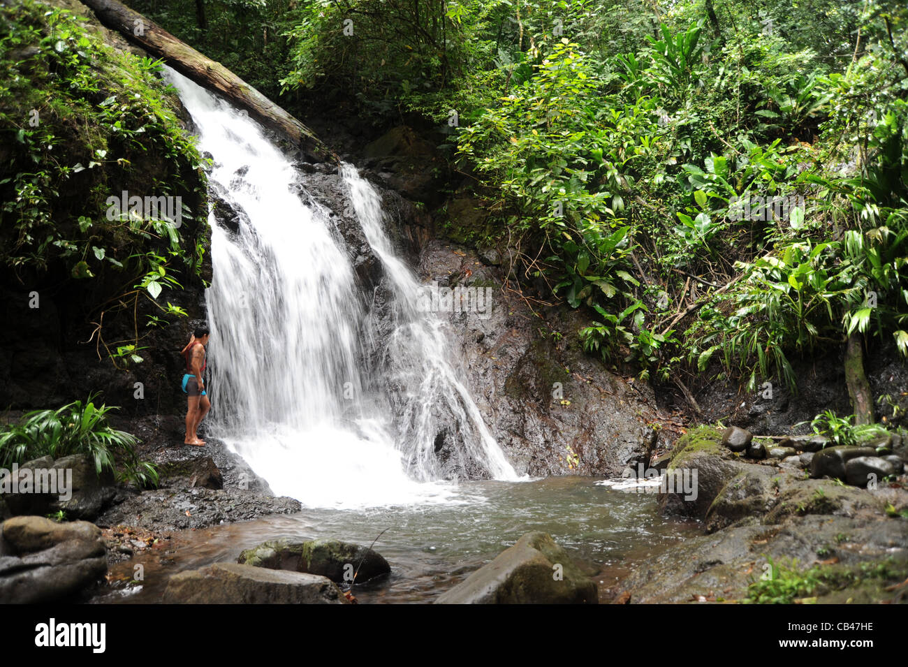Hombre indígena Embera en una cascada del río Chagres en la comunidad indígena Embera Puru en Panamá. Foto de stock