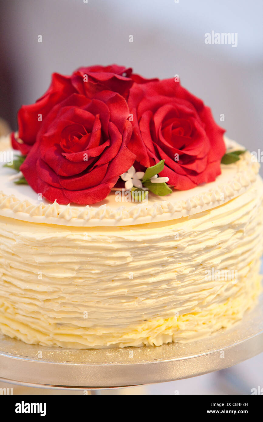 Pastel de boda blanco con rosas rojas en la parte superior Fotografía de  stock - Alamy