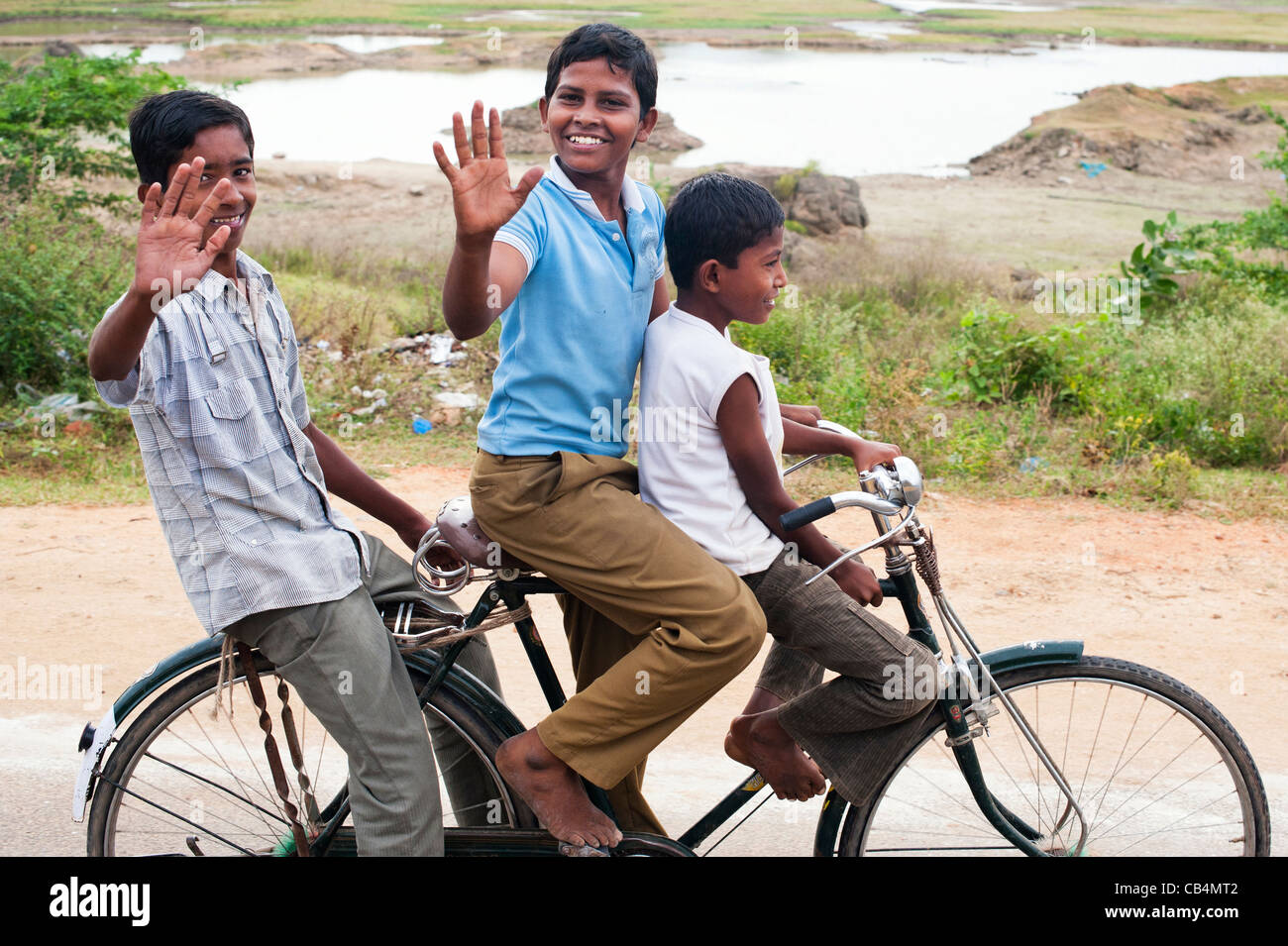 Tres niños indios a montar una bicicleta. En Andhra Pradesh, India