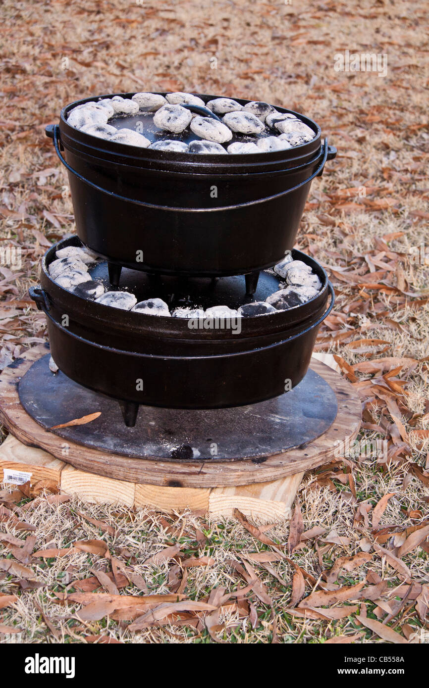 Horno holandés, cocinar al aire libre usando potes apilados con base de  metal de apoyo Fotografía de stock - Alamy