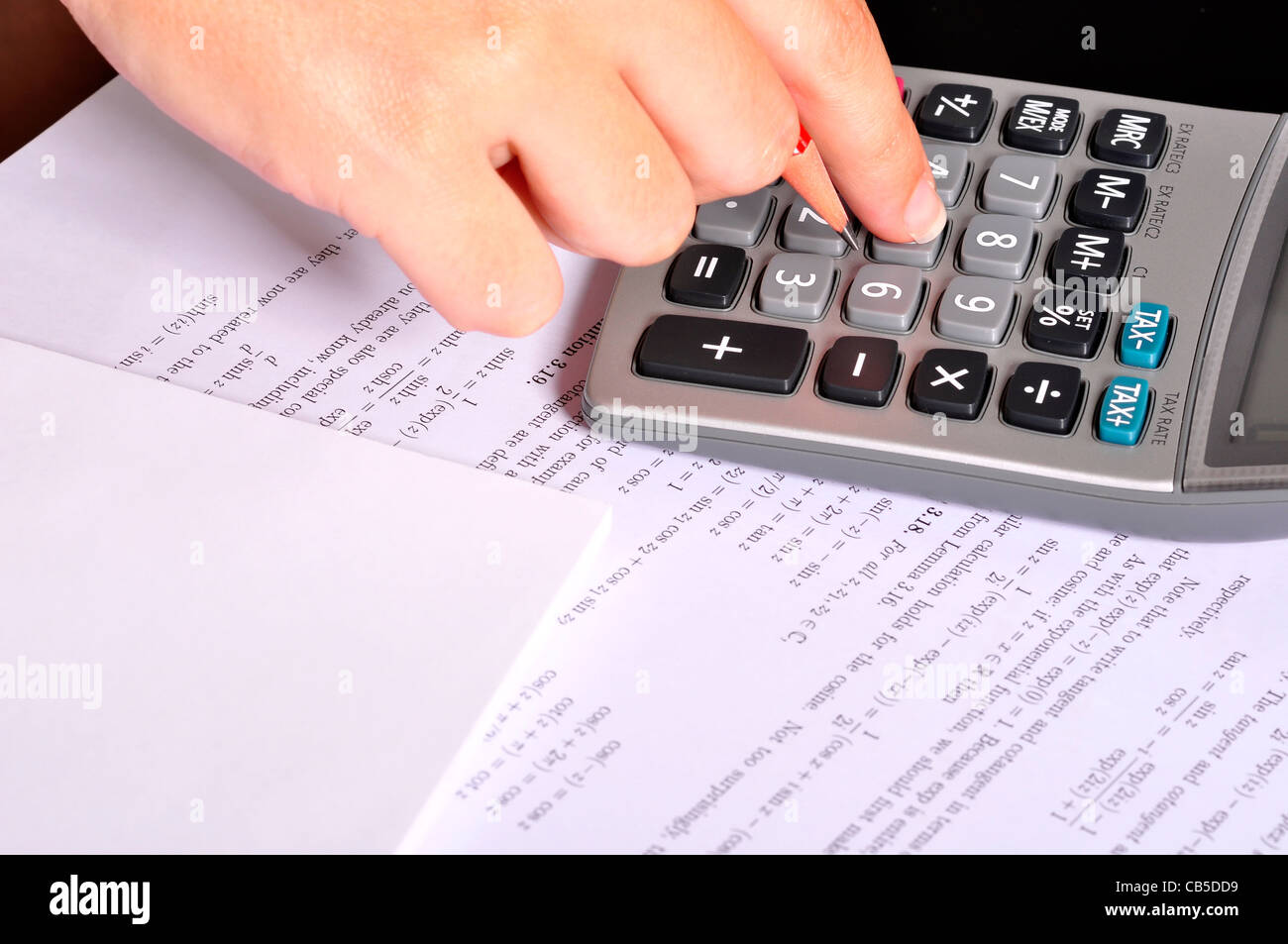 Estudiante haciendo ejercicios de matemáticas con una calculadora y un  lápiz rojo Fotografía de stock - Alamy