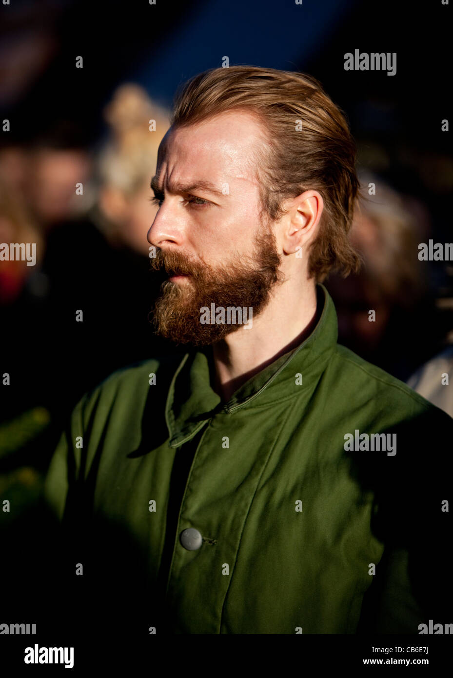 Retrato en la cabeza de un hombre barbudo parado en la multitud mirando hacia fuera, Londres, Inglaterra, Reino Unido. Foto de stock