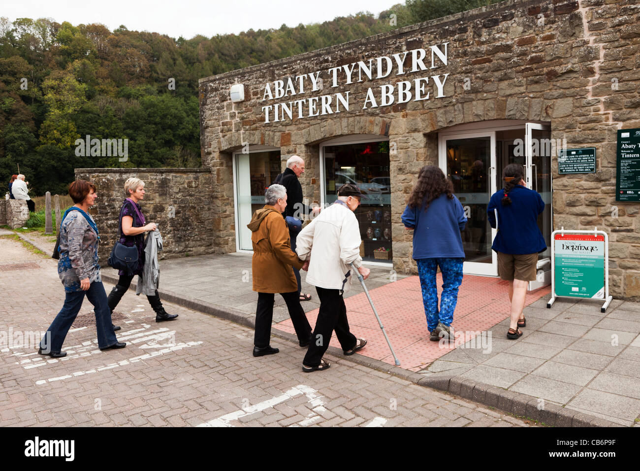 La gente caminando en la entrada a la Abadía de Tintern propiedad CADW en Gales UK Foto de stock