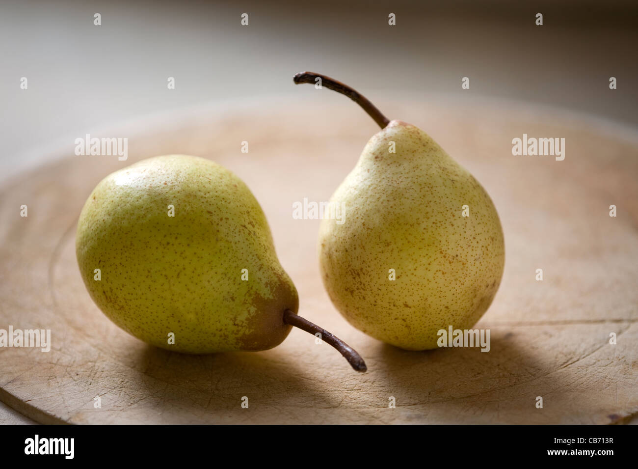 Dos peras Rocha en una tabla de cortar de madera Foto de stock