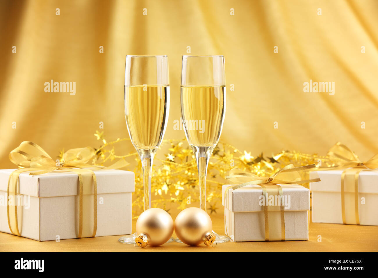 Copas de champán con cajas de regalos y bolas de Navidad. Foto de stock