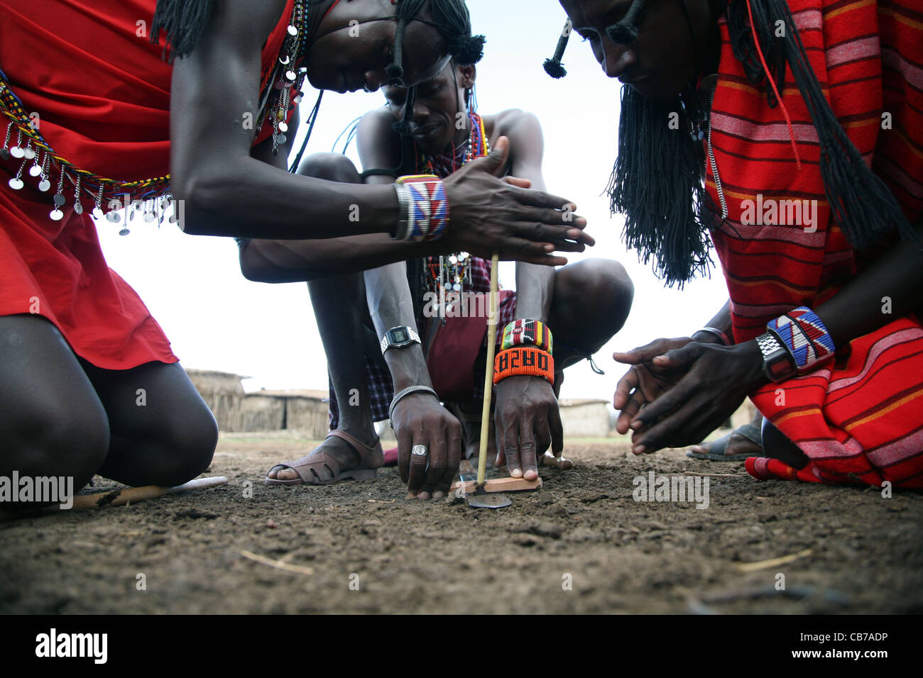 Los jóvenes masai comienzan un fuego de fricción frotando dos palos juntos en su aldea en la Reserva Nacional Masai Mara, Kenia. 2/2/2009. Fotografía: Foto de stock