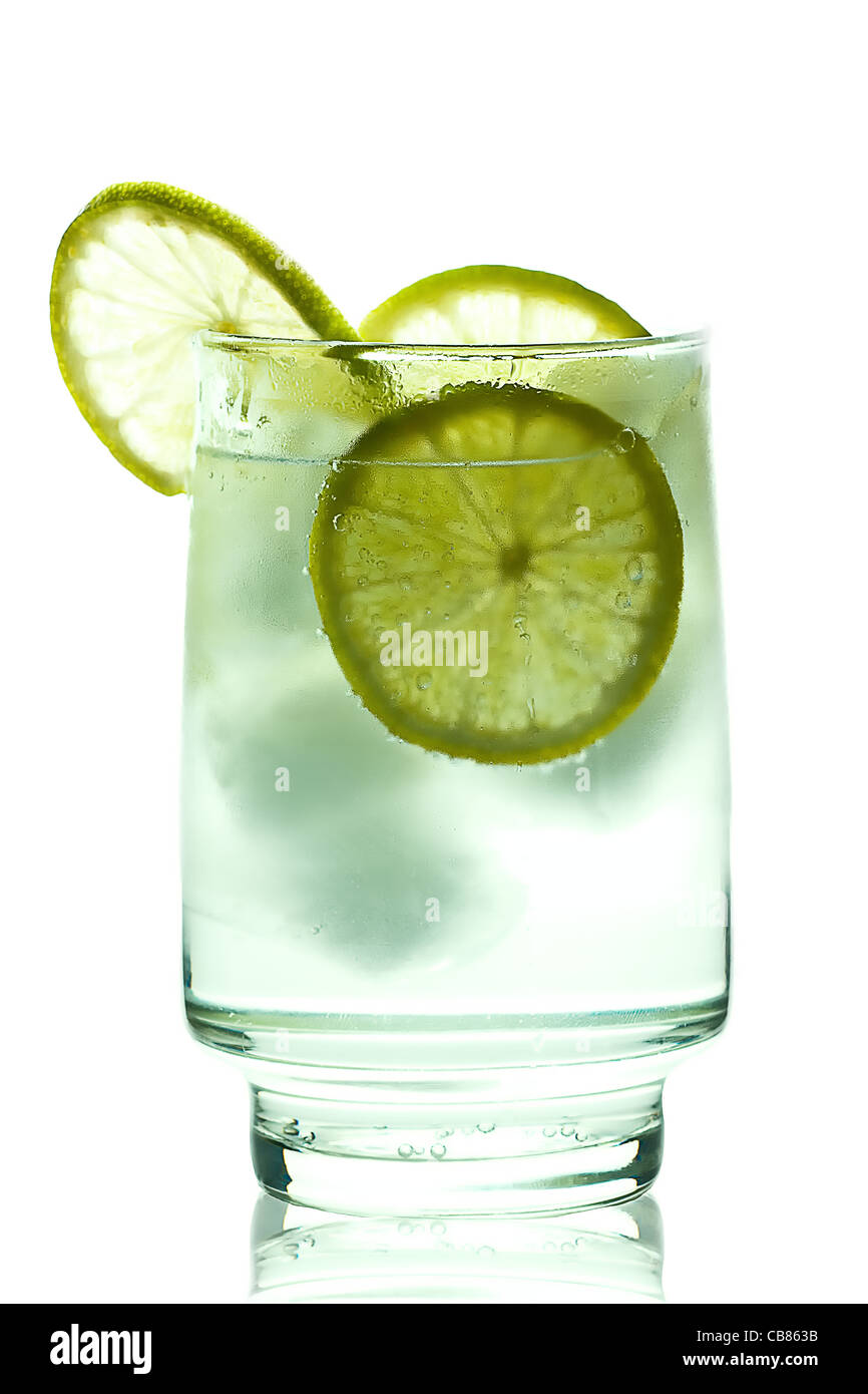 Vaso de gin tonic con cubos de hielo y rodajas de limón. aislado en blanco Foto de stock