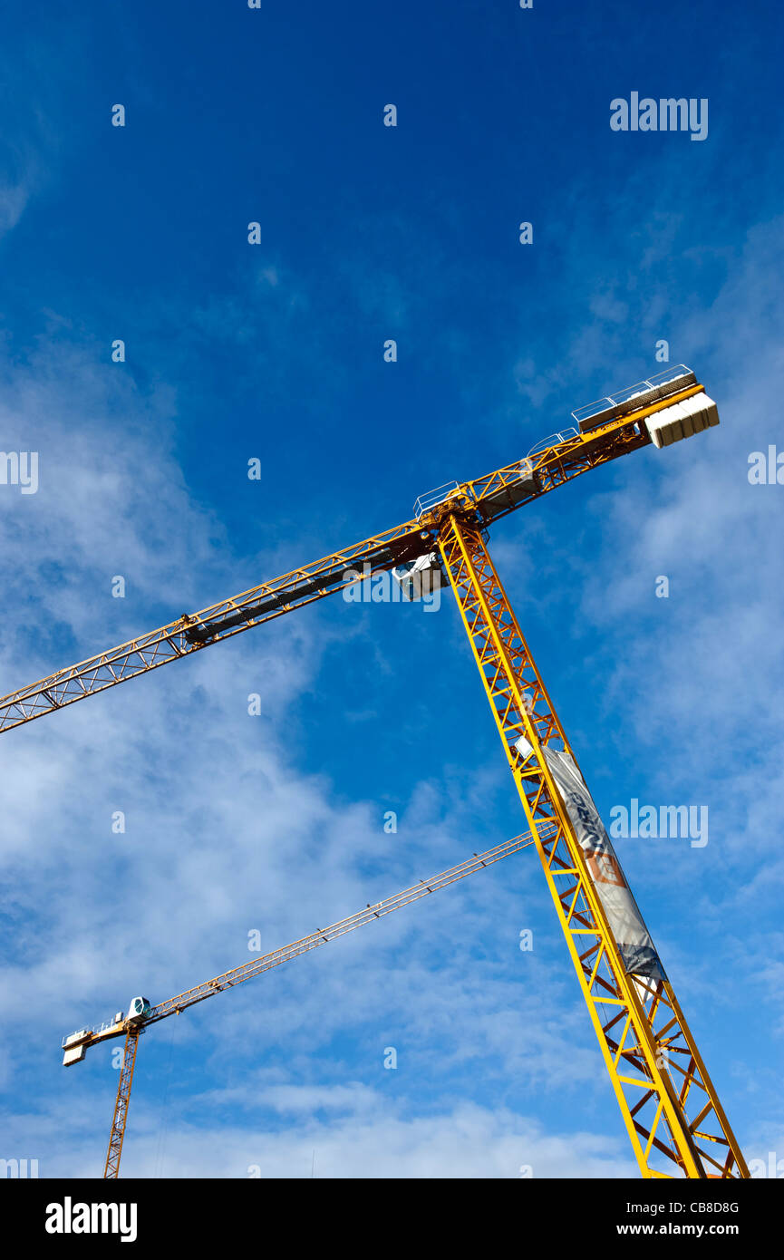 Grúas de construcción contra un cielo azul Foto de stock