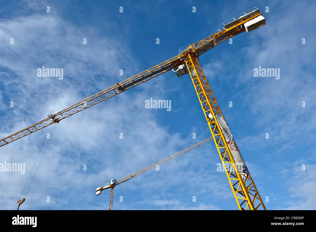 Grúas de construcción contra un cielo azul Foto de stock