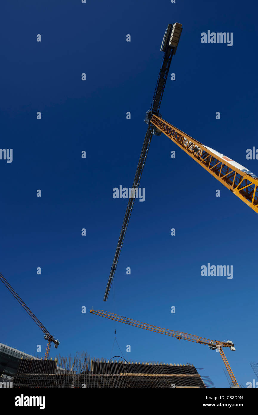 Grúas de construcción contra un cielo azul Foto de stock