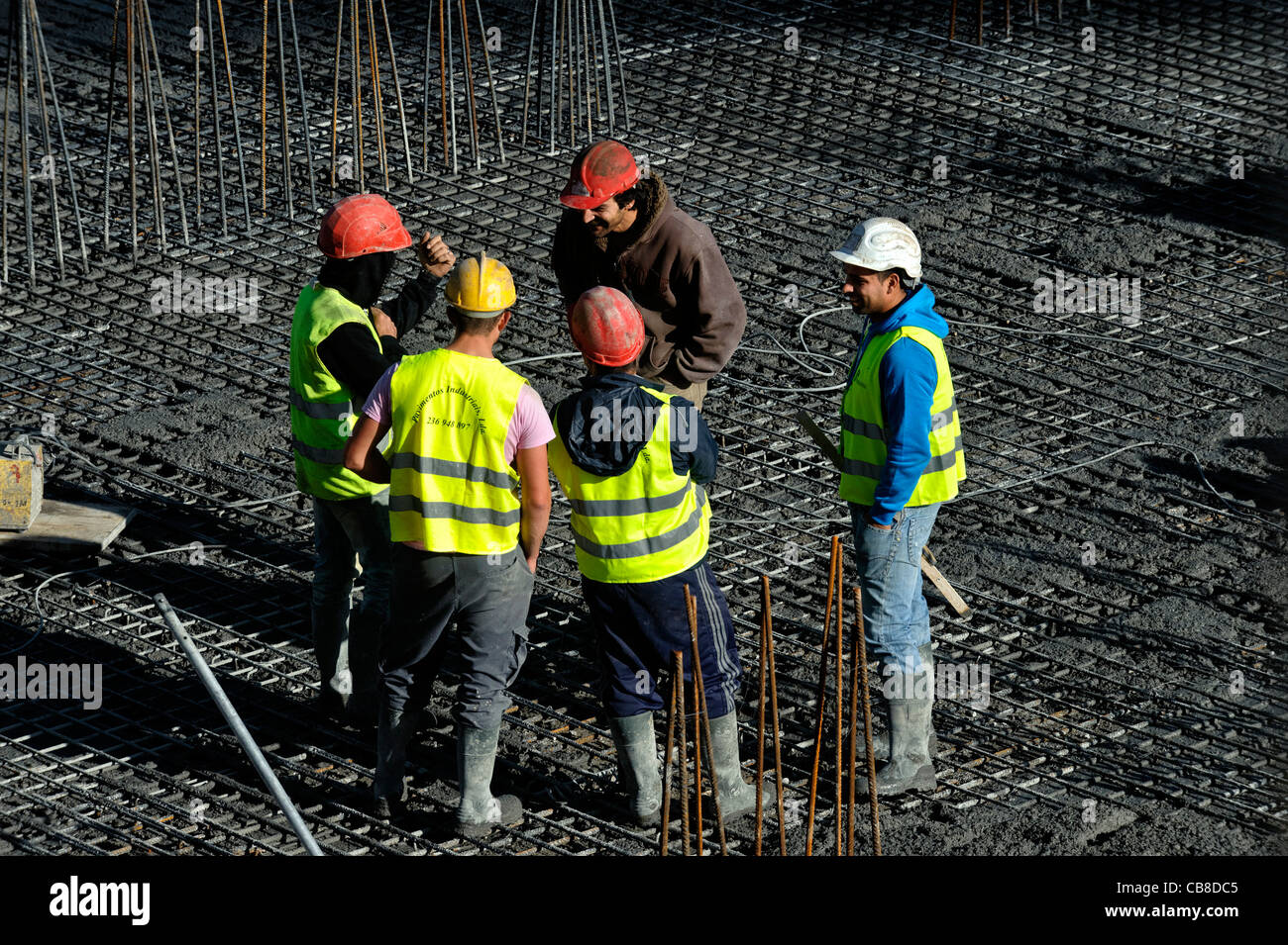 Los trabajadores de la construcción conversando mientras un descanso en un sitio en construcción Foto de stock