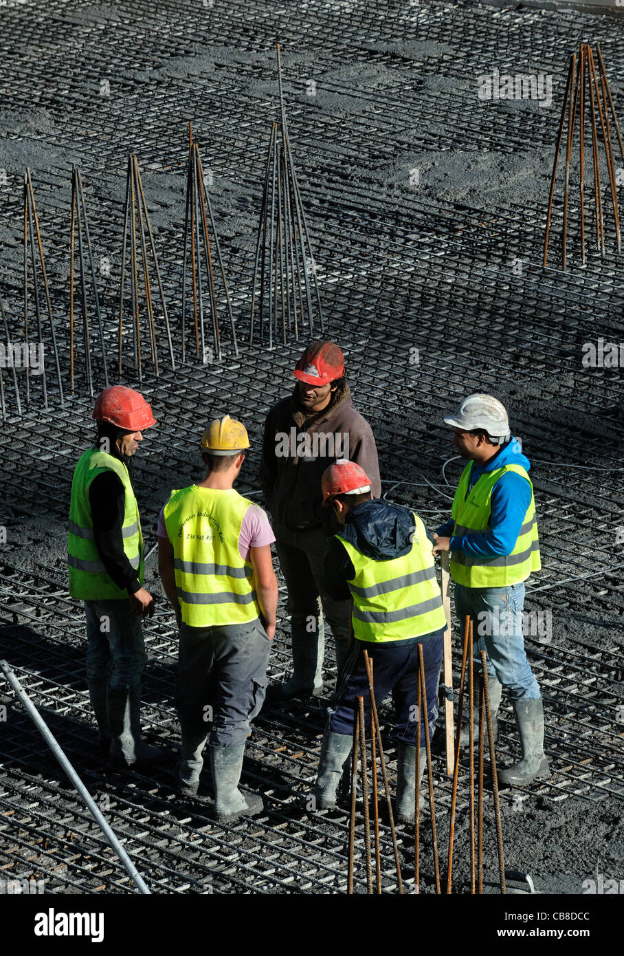 Los trabajadores de la construcción conversando mientras un descanso en un sitio en construcción Foto de stock