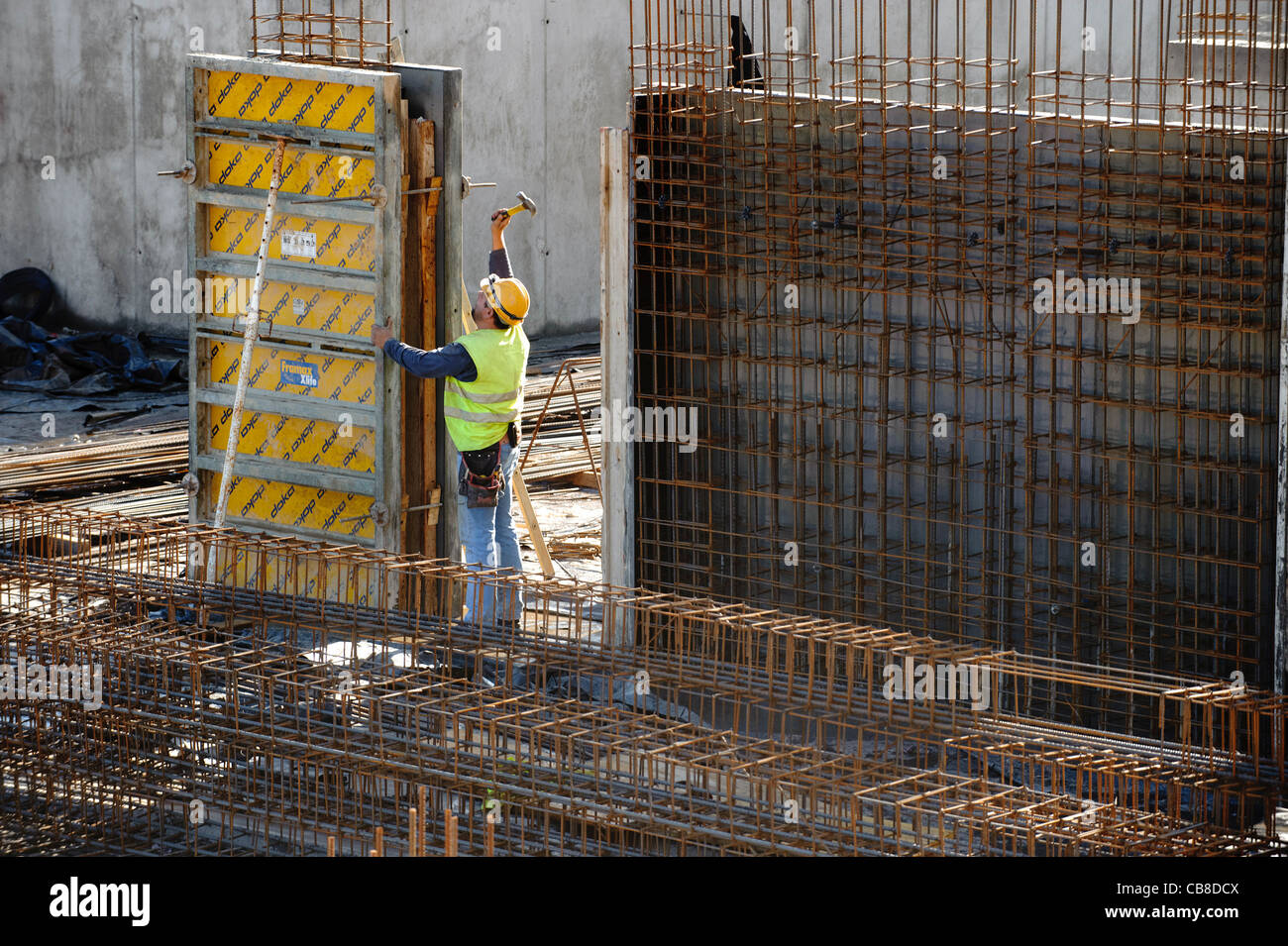 Trabajador de la construcción en una obra de construcción de martilleo Foto de stock