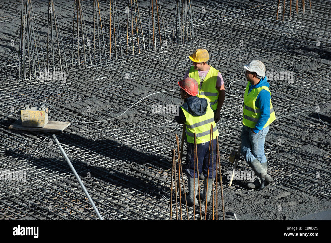 Los trabajadores de la construcción conversando mientras toma un descanso en un sitio en construcción Foto de stock
