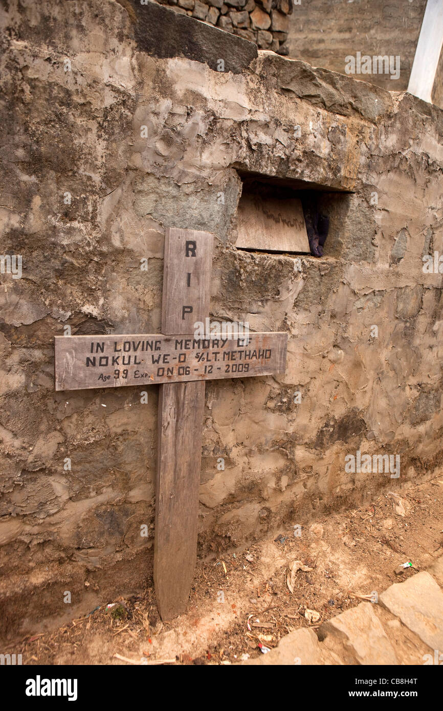 India, Nagaland, Jakhama, cruz cristiana lápida, junto con el agujero en el muro de piedra que contiene el cuerpo Foto de stock