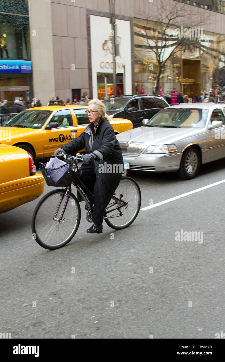 La Ciudad de Nueva York mujer senior paseos su bicicleta en Nueva York Street. Foto de stock