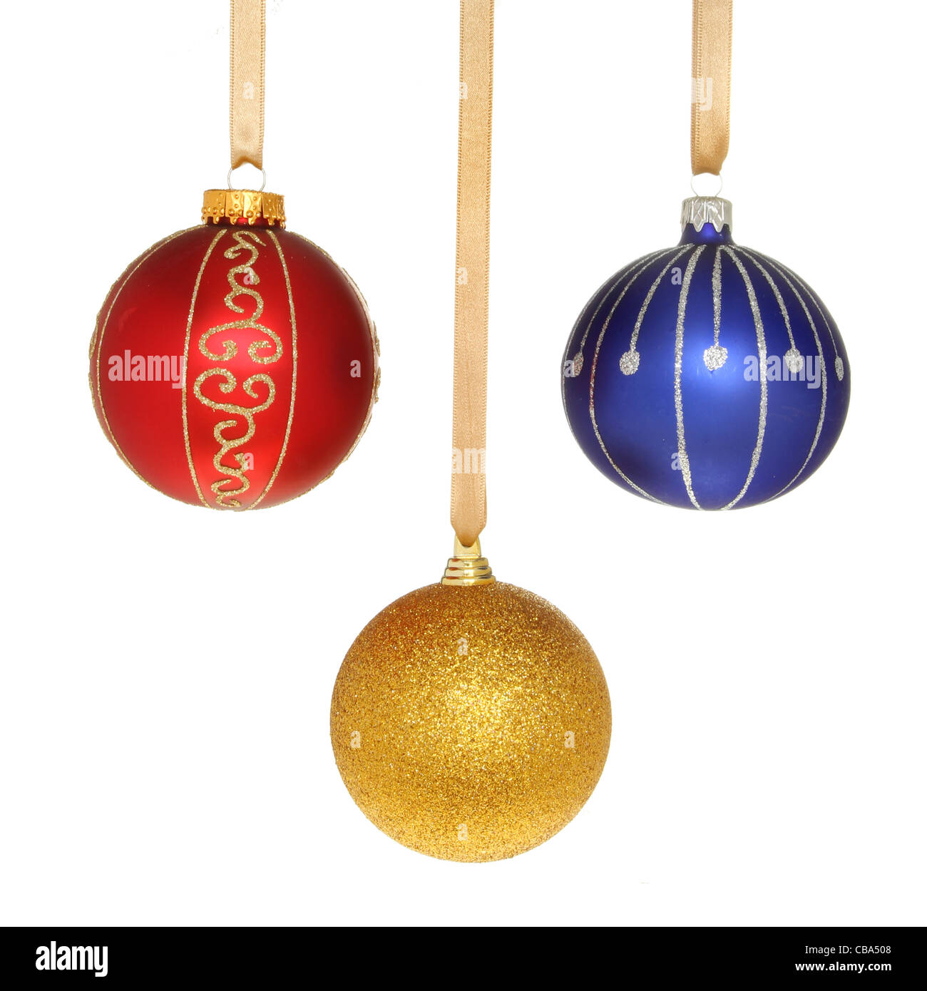 Tres bolas de Navidad colgando de cintas de oro contra un blanco aislado Foto de stock