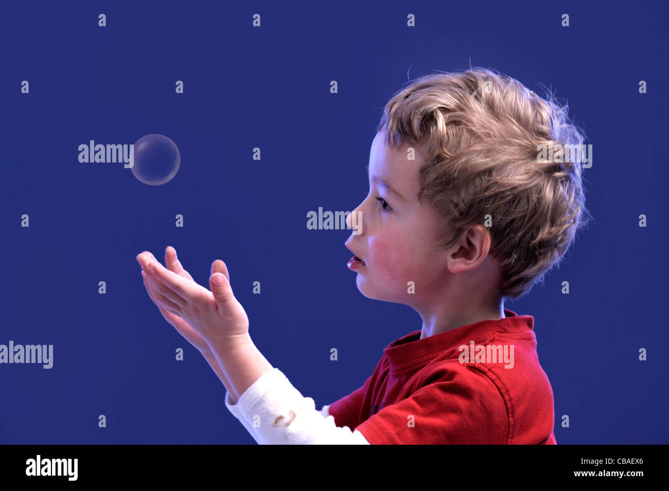 Niño jugando con una burbuja de aire Foto de stock