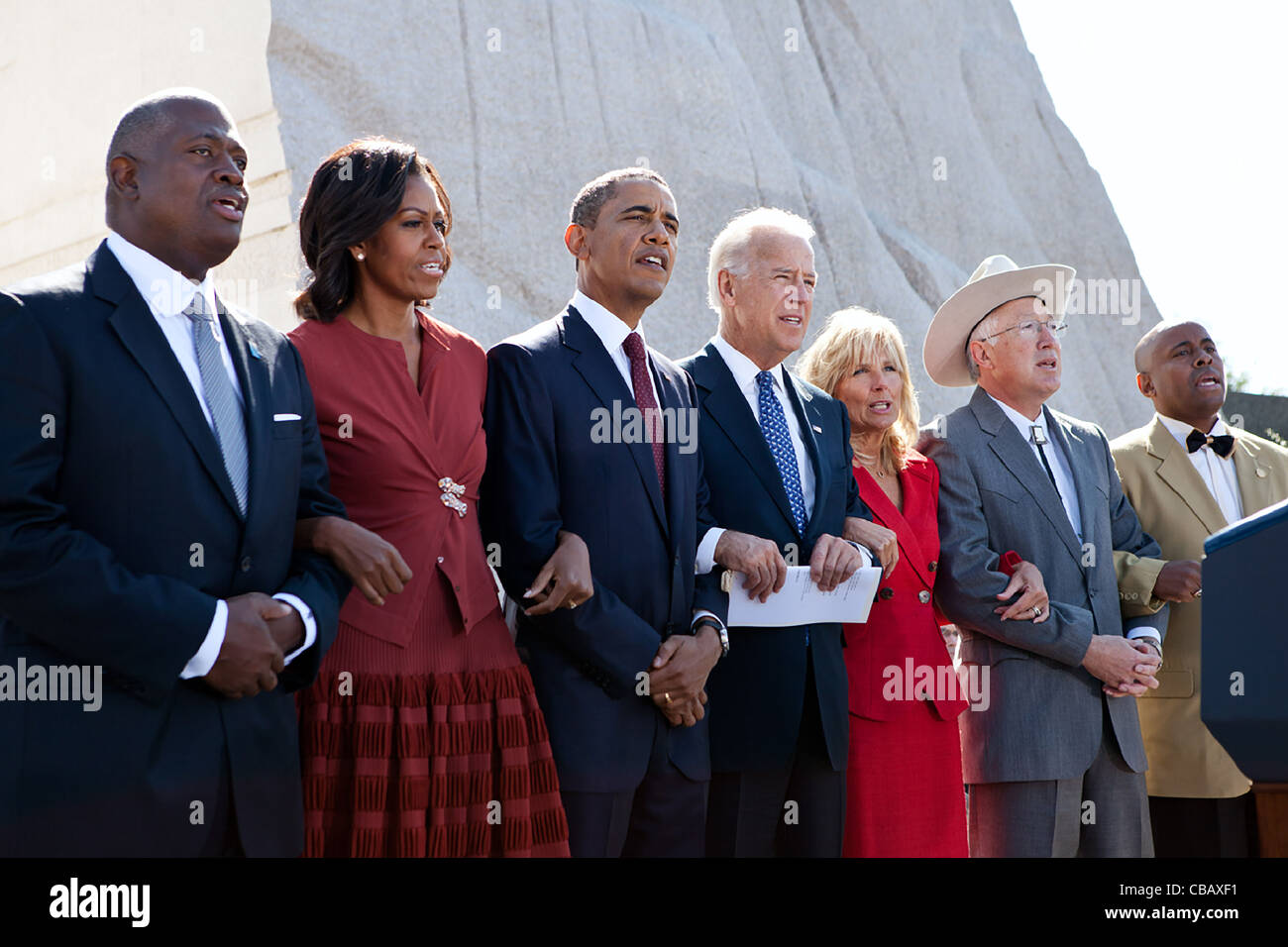 El presidente Barack Obama, la Primera Dama Michelle Obama, el vicepresidente Joe Biden y la Dra. Jill Biden los brazos y cantar "Venceremos" durante la ceremonia para el Día de Martin Luther King Jr. Memorial Nacional del 16 de octubre de 2011 en Washington, DC. Unirse a ellos, de izquierda a derecha son: Harry Johnson, Sor; Foto de stock