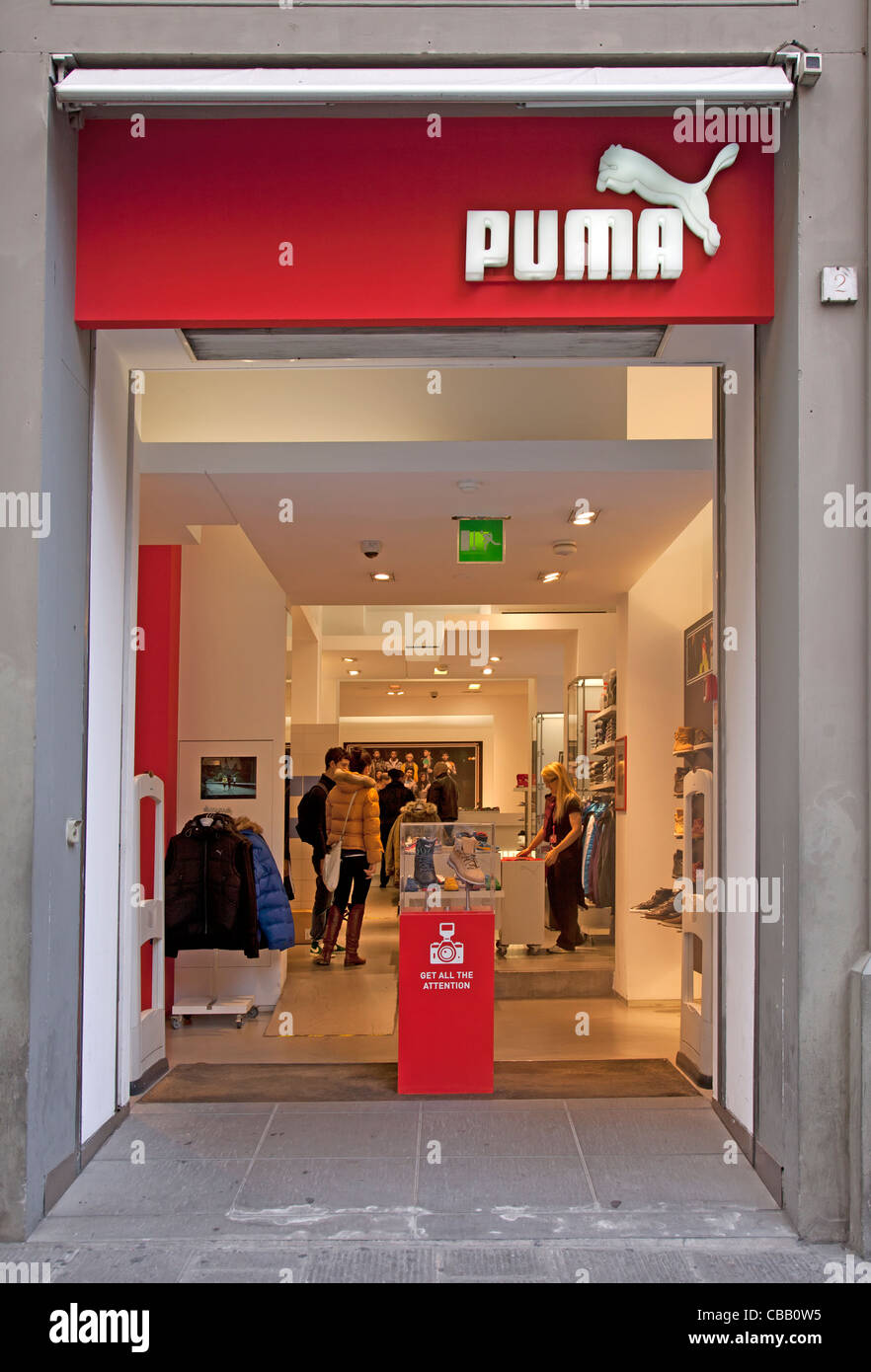 Entrada a una tienda de ropa deportiva Puma y al aire libre en el de Florencia, Italia. Algunos clientes y un asistente puede ser visto Fotografía de stock -