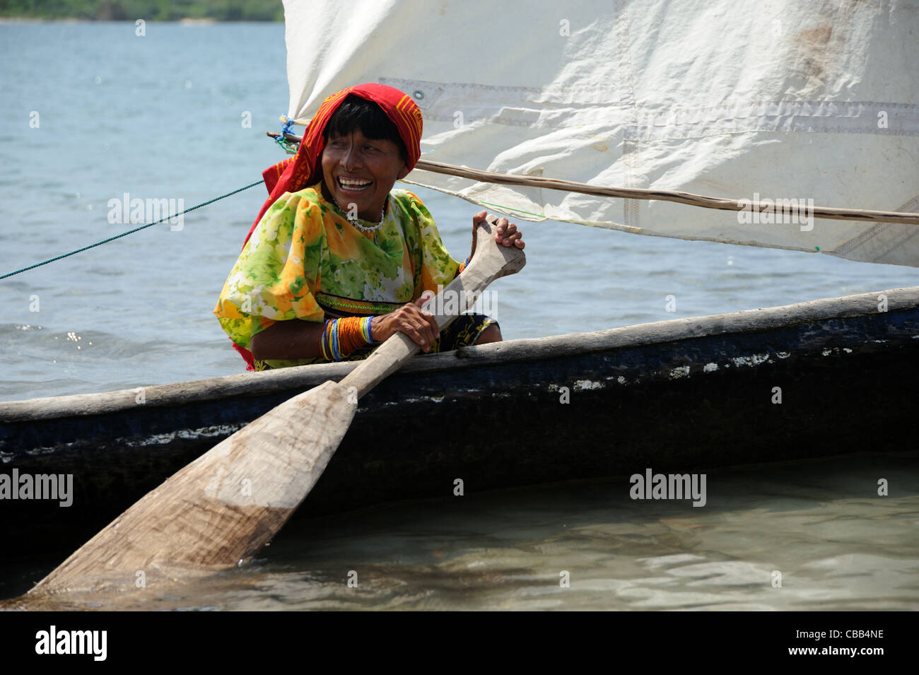 Mujer indígena guna remar en un cayuco en la isla Corbisky en Guna Yala, Panamá. Foto de stock