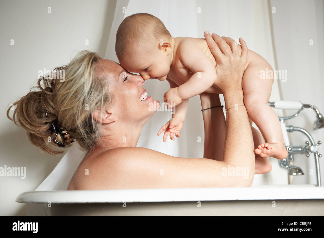 Madre sonriente de bañarse con el bebé Foto de stock