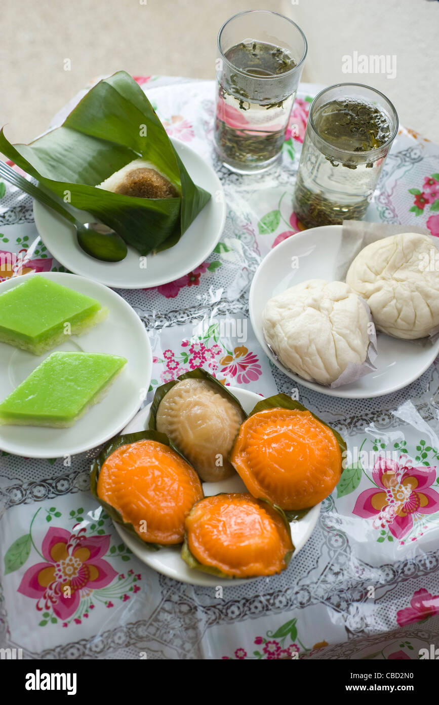 Surtido de tarifa: malayo-mueh kueh (pasteles de arroz), panecillos cocidos, pulut inti y té Foto de stock