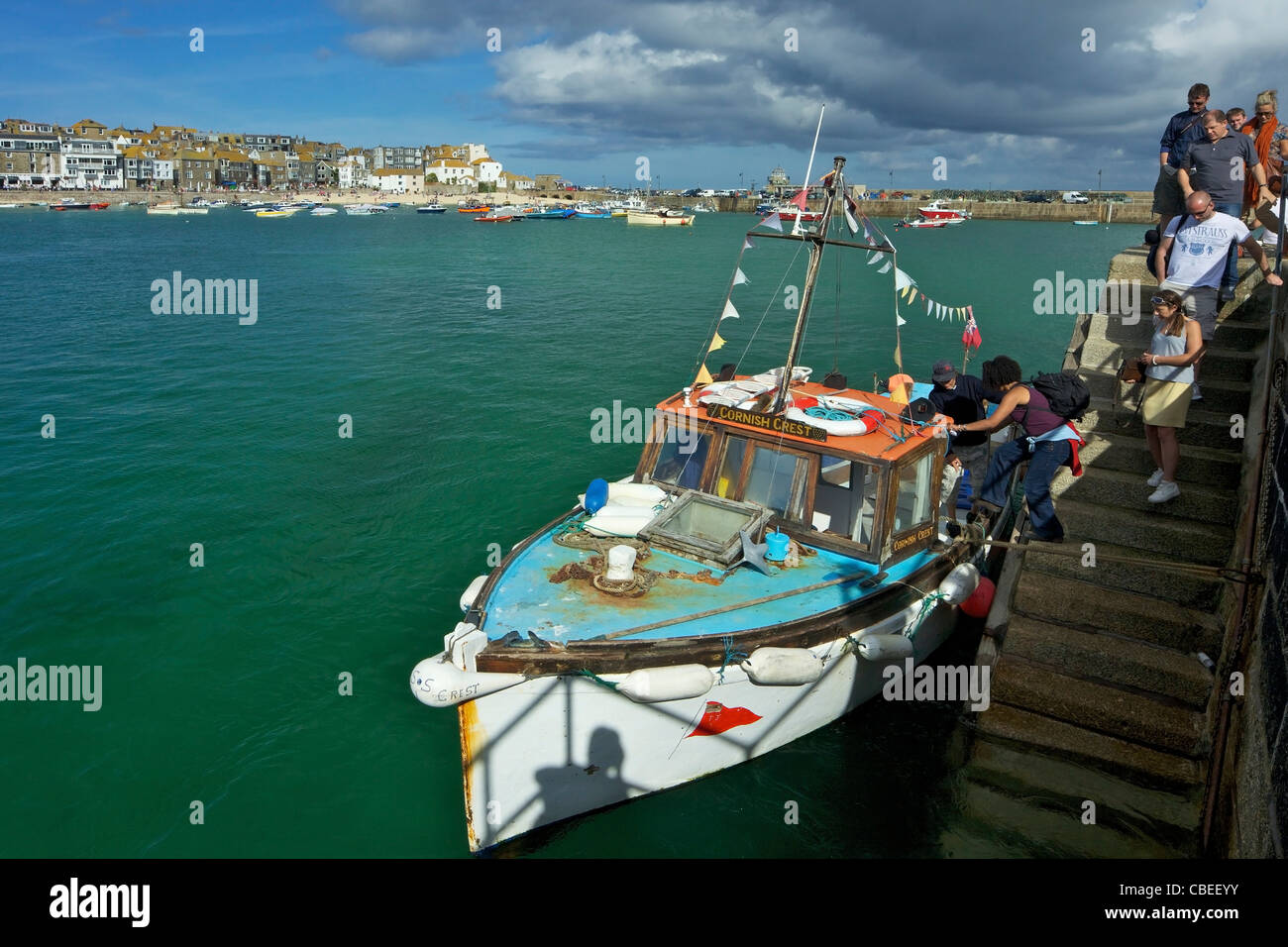 Los turistas que salen de viaje en barco de verano en Old Harbour, St Ives, Cornwall, en el suroeste de Inglaterra, UK, Reino Unido, GB, Gran Bretaña Foto de stock