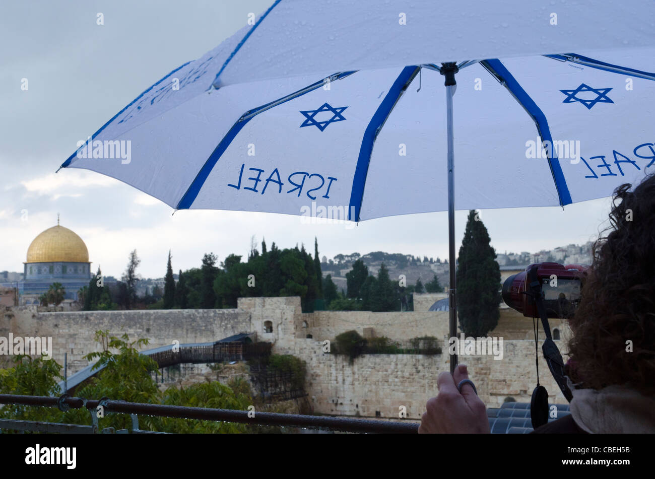 Turista con paraguas mirando la cúpula dorada en un día lluvioso. Ciudad Vieja de Jerusalén ISRAEL. Foto de stock