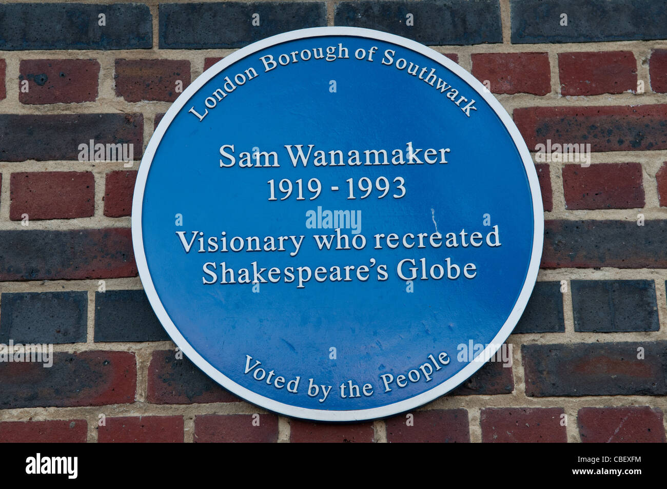 Placa azul en conmemoración de Sam Wanamaker, visionario que recrea el Shakespeare's Globe Theatre, Bankside, Londres, Inglaterra, Reino Unido. Foto de stock