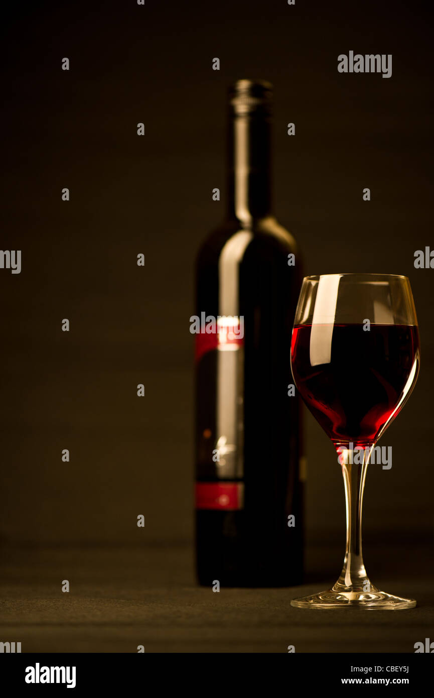 Copa de vino tinto con botella Foto de stock