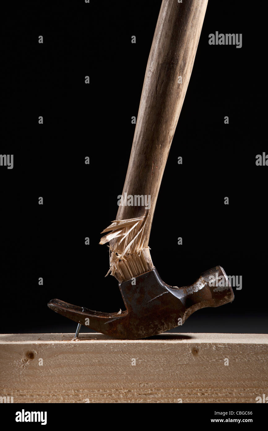 Un mango del martillo romper al intentar quitar un clavo de una viga Foto de stock