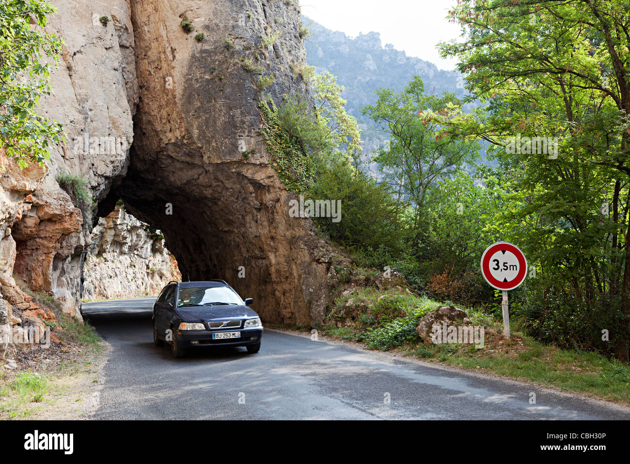 Coche de conducción a través de túnel en roca con limitación de altura en la carretera hacia abajo las Gorges du Tarn, Francia Foto de stock
