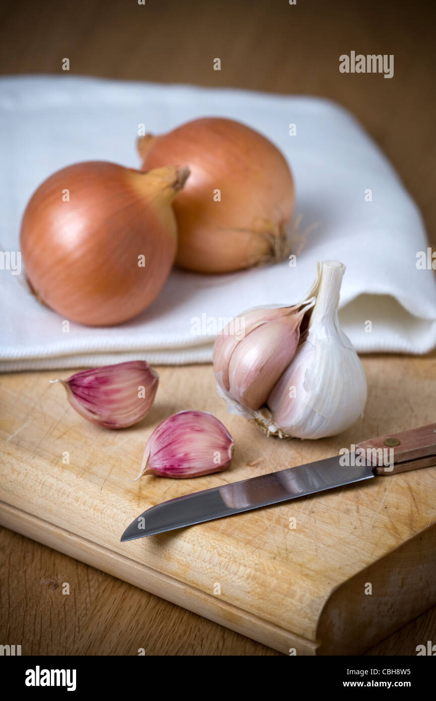 Ajos y cebolla en tabla de cortar