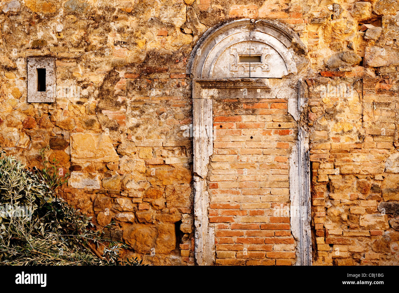 En la pared de la antigua villa medieval de San Quirico d'Orcia, sitio de Patrimonio Mundial de la Unesco, Toscana, Italia Foto de stock