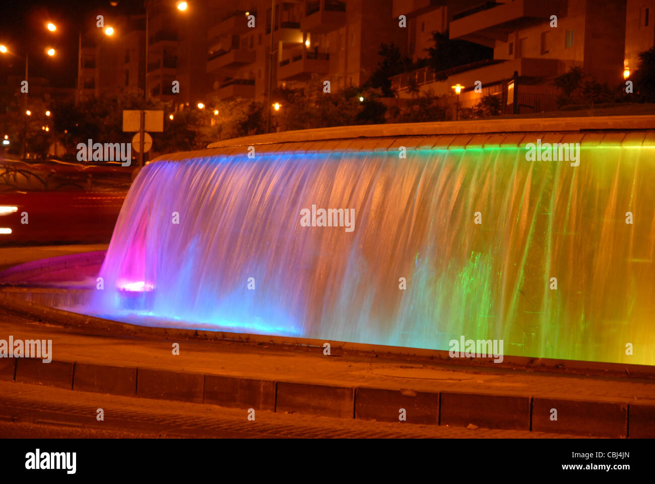 Fuente de color durante la noche una ciudad brillante en la vía Foto de stock