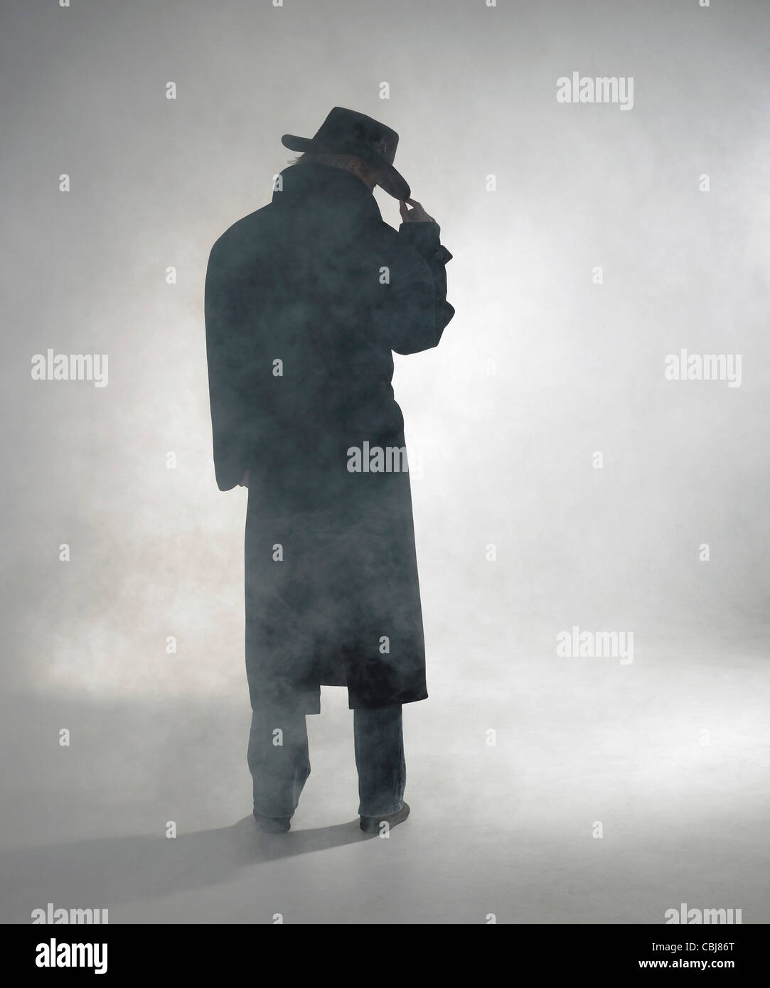 Mujer con abrigo oscuro en la niebla permanente Foto de stock