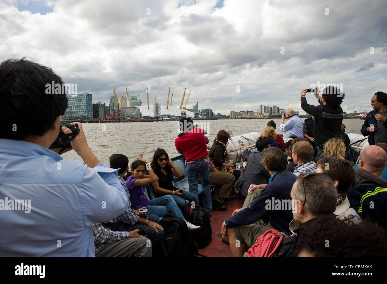 Los turistas en una excursión guiada en barco del río Támesis, Londres, Reino Unido. Foto de stock