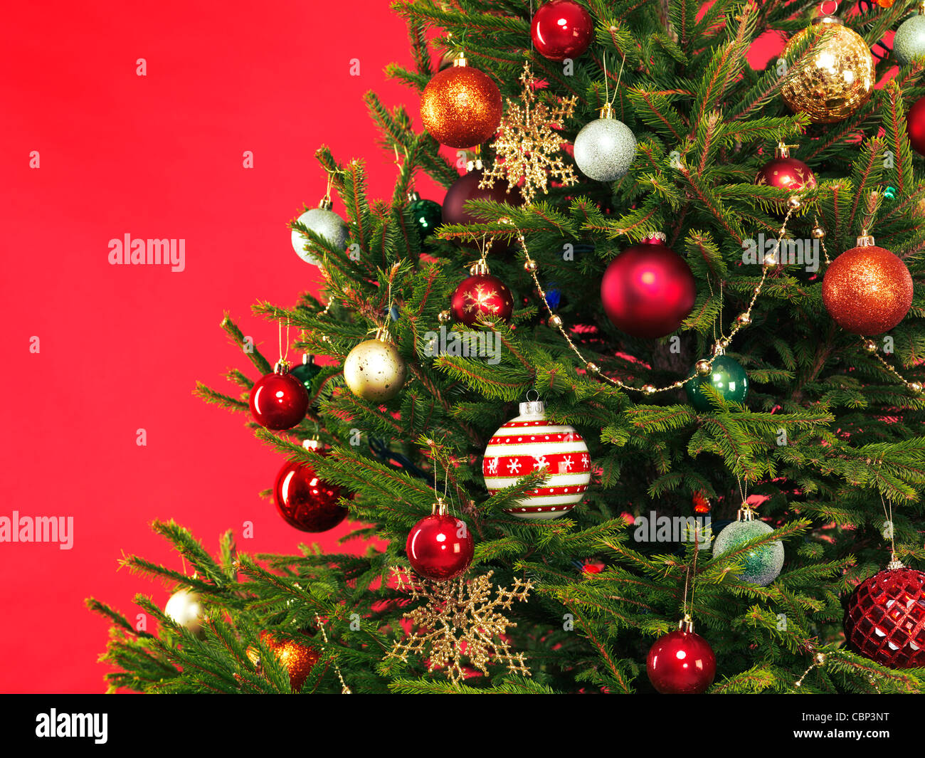 Primer plano de una colorida decoración del árbol de Navidad sobre fondo rojo brillante Foto de stock
