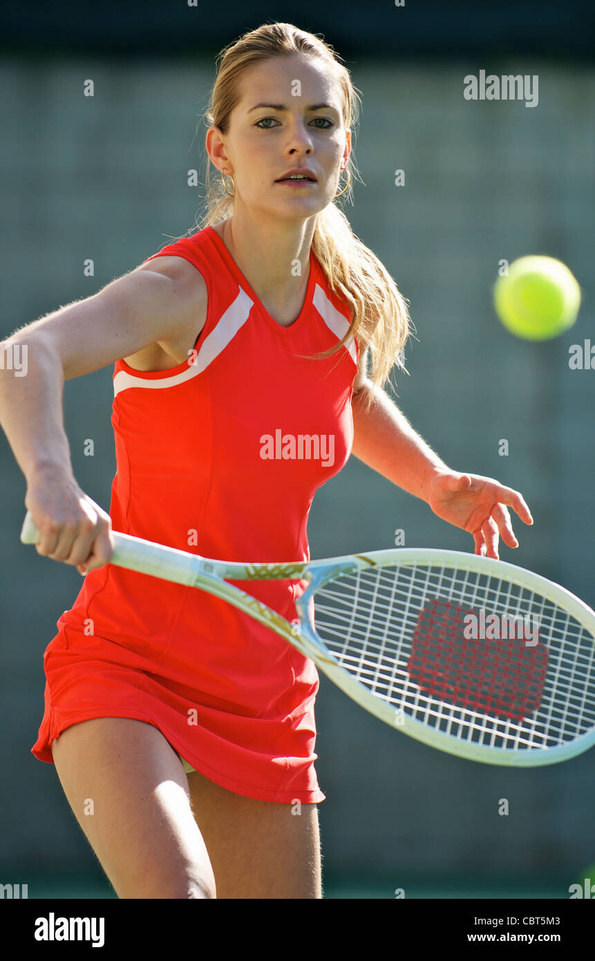 Una mujer jugando al tenis. Foto de stock