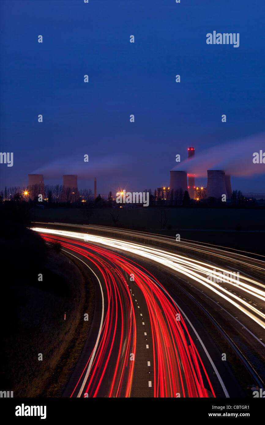 Tráfico por la noche pasar corriendo una potencia de generación de electricidad con carbón, la estación de Didcot, Oxon, reino unido Foto de stock