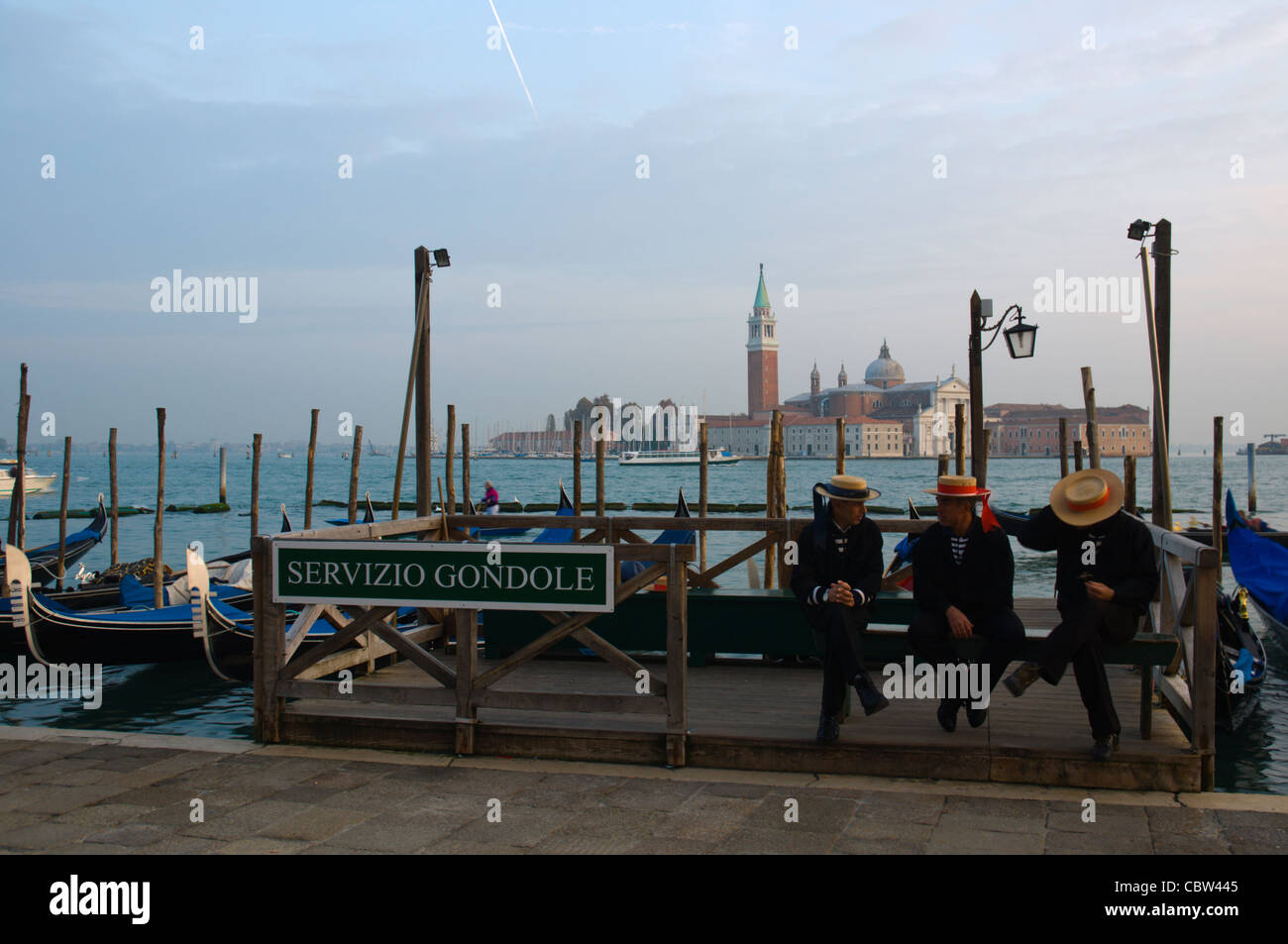 Gondoleros esperando que conduzca al Molo waterfront en frente de la bahía Bacino di San Marco, Venecia Italia Foto de stock