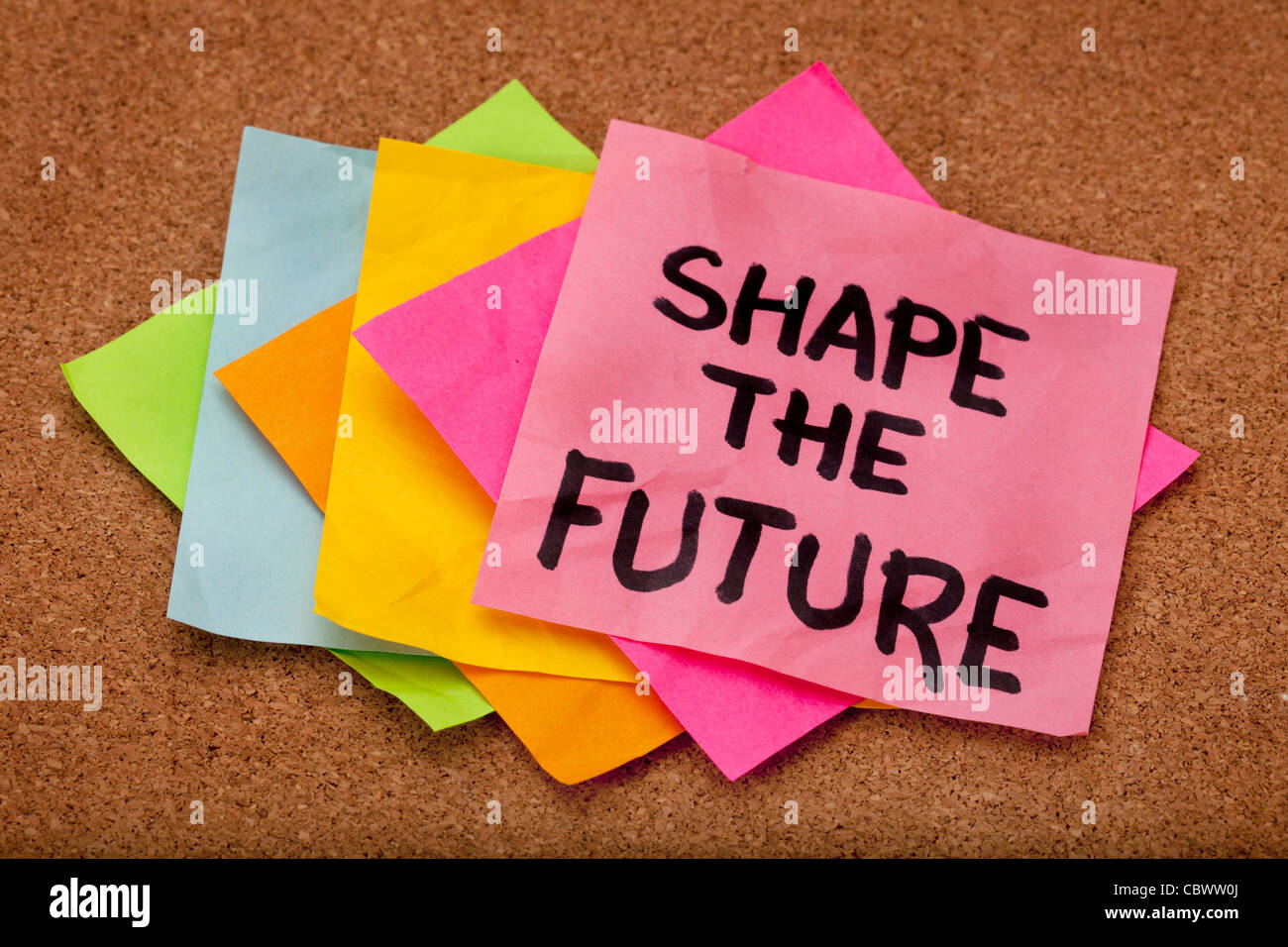 Moldear el futuro, lema motivacional, coloridas notas rápidas en el tablón de anuncios de corcho Foto de stock