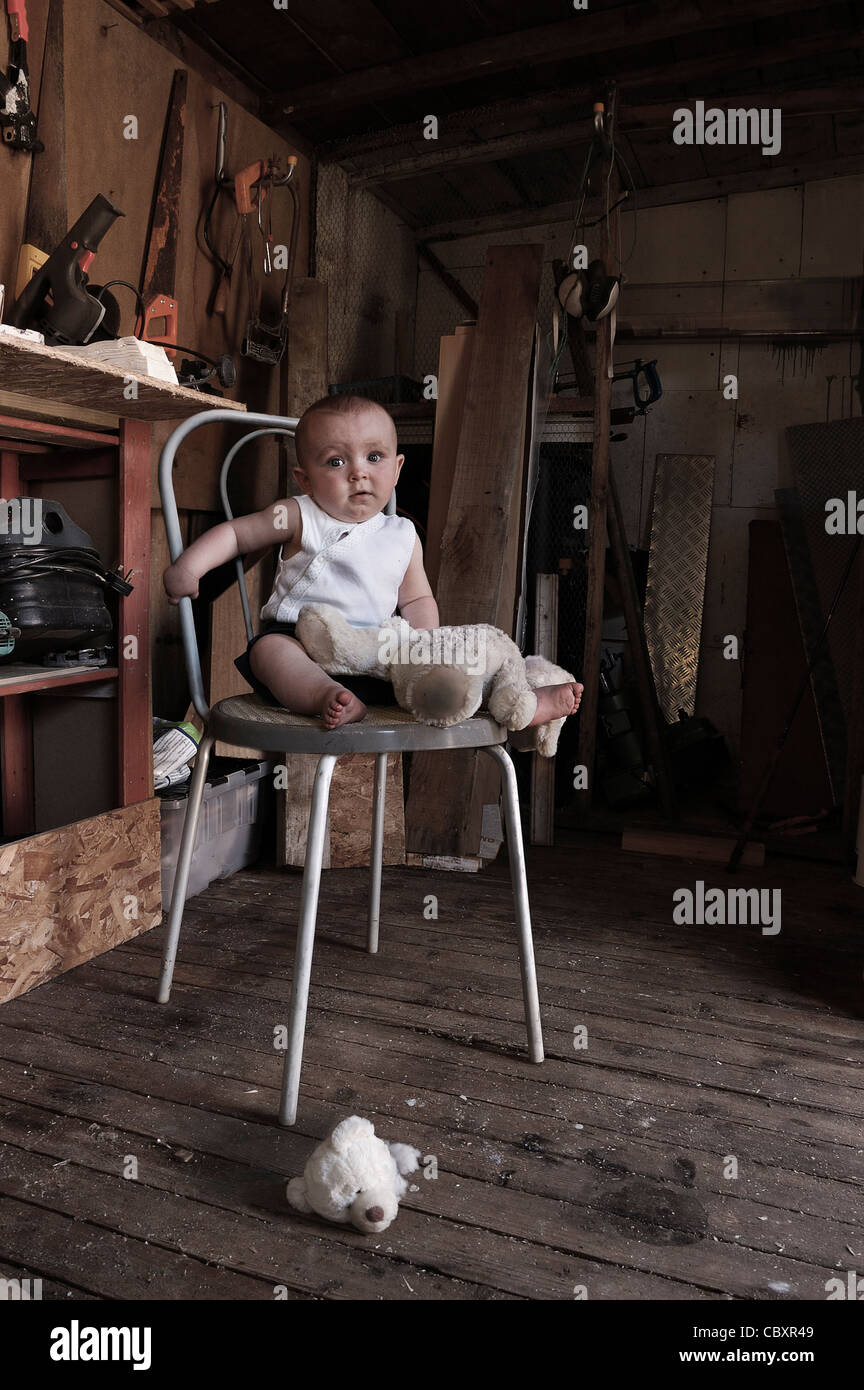 Triste Frente Nino Pequeno Con Juguete Roto Sentado En Una Silla En El Taller Fotografia De Stock Alamy