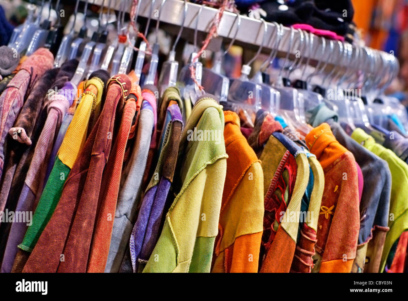 Colorida ropa colgando de un perchero en una tienda minorista. Foto de stock
