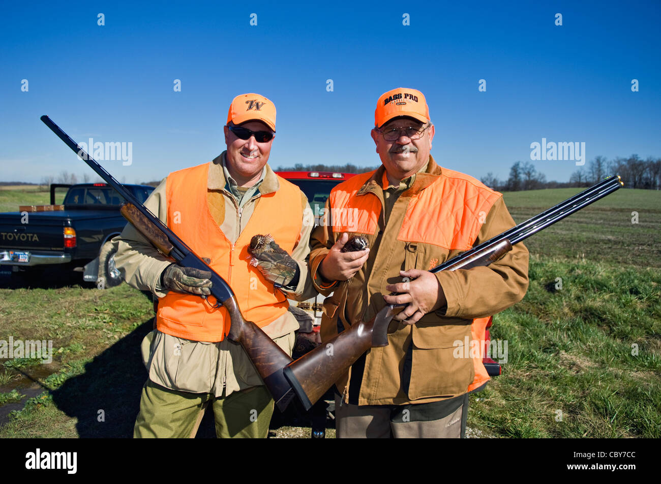 Dos cazadores de aves de montaña posando con escopetas y codornices Foto de stock