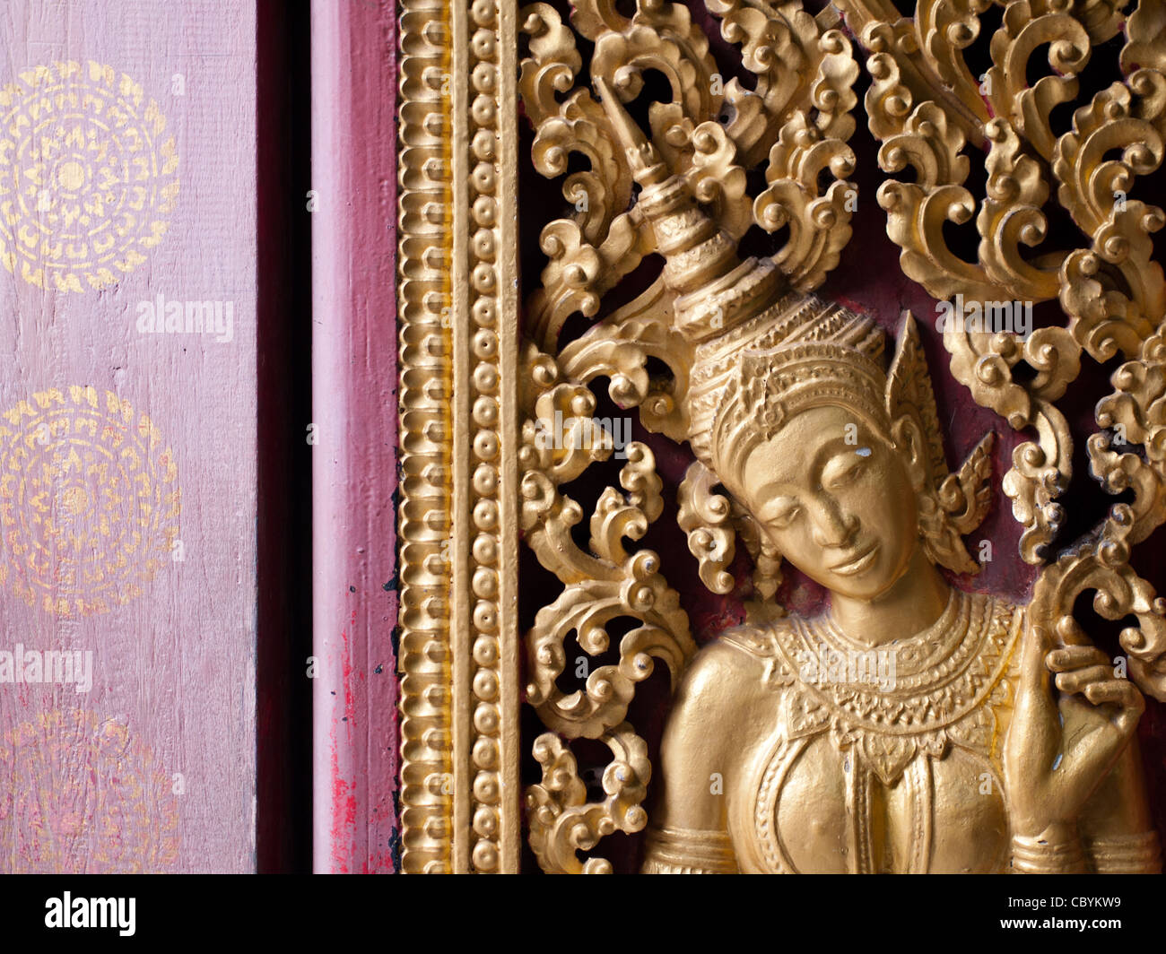 Un Buda en los intrincados muros de Wat Xieng Thong en Luang Prabang, Laos. Foto de stock