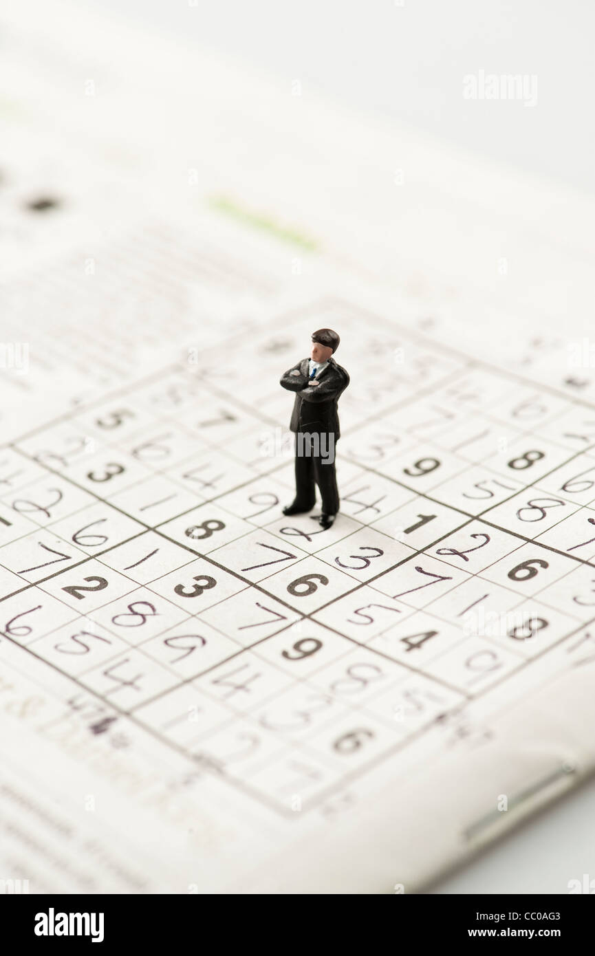 Una pequeña figura de un hombre en un rompecabezas Sudoku Foto de stock